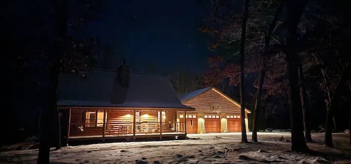 The cabin and garage glowing on a snowy night